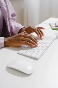 A person's hands on a keyboard, typing.